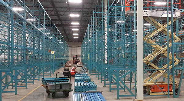 Blue pallet rack system being installed in a large warehouse